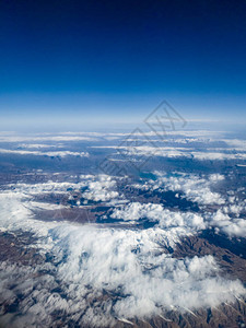 鸟儿对高山顶上满是雪的云层的观视呈现图片
