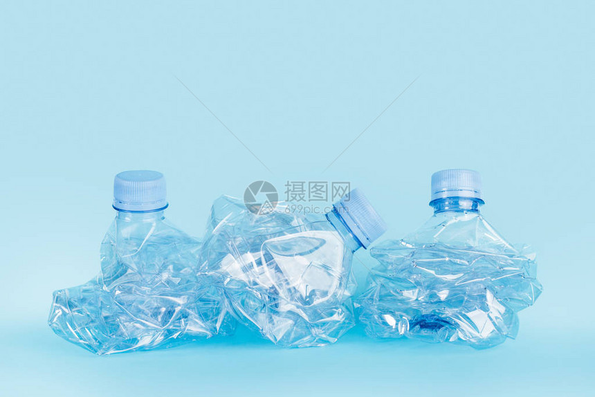 蓝色背景中压碎的空水瓶图片