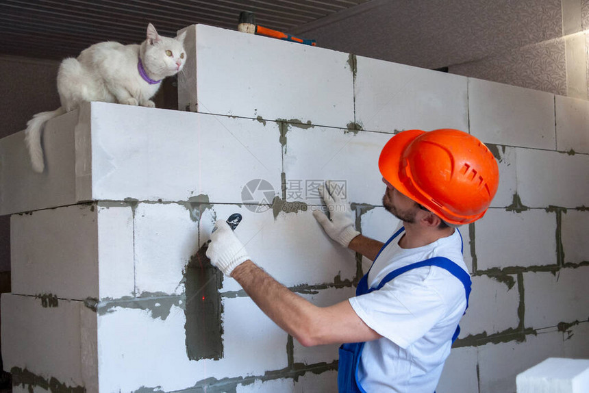 工头师傅在盖房子时放了一堵加气混凝土砌块的墙私人住宅建设用于建造加气混凝土砌块的现图片