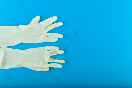 蓝色背景上的白手套蓝色背景的白色乳胶手套背景图片