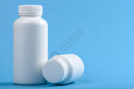 两瓶白色药用塑料瓶蓝色背景图片