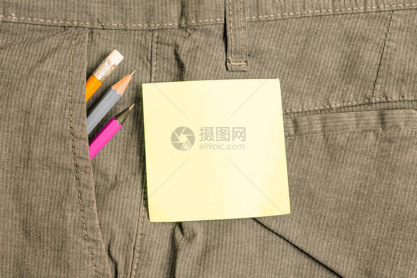 男子工作裤口袋内写作设备和绿色纸图片