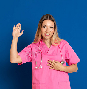 蓝色背景上穿着粉色制服的金发医生图片