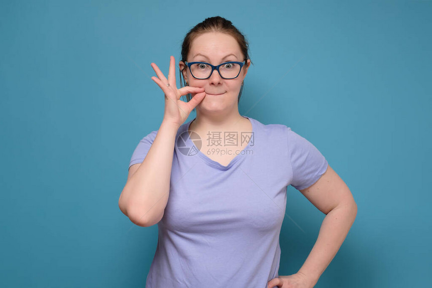 年轻的白种女人手牵靠近嘴巴图片