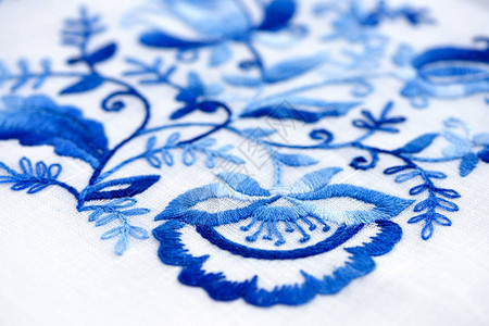 薄画布上的手刺绣缝纫白色背景的蓝花纹装饰品艺术图片