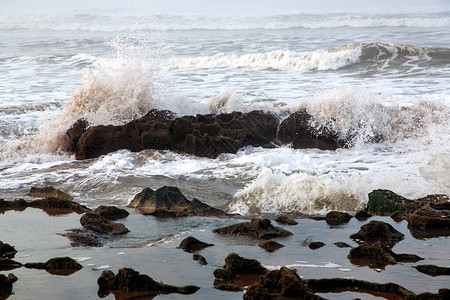 摩洛哥卡萨布兰卡大西洋的岩石海岸上拍打着白色泡沫的图片