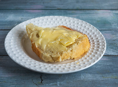 配黄油和蜂蜜的快餐面包白色盘子上图片