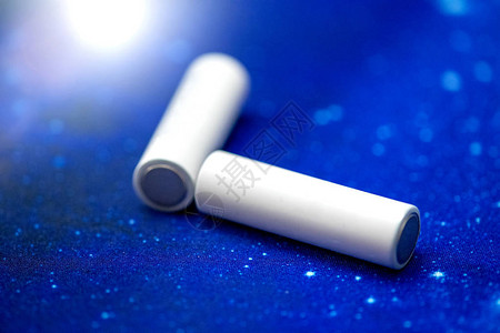 几个白色AA电池在蓝色背景图片
