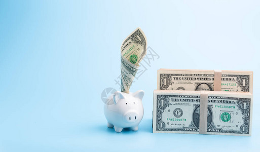 关于蓝背景储蓄和投资概念的小猪银行和一叠美图片