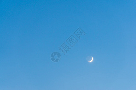 湛蓝天空中的新月和照图片