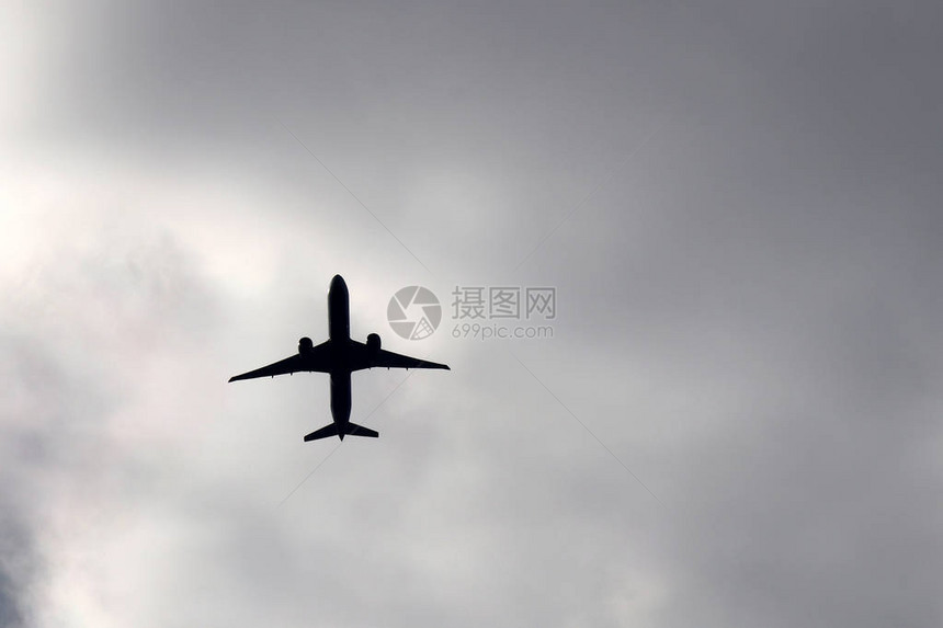 空中飞机在暴风云背景下飞行图片