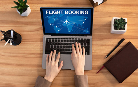 乘坐笔记本电脑规划度假到国外坐在室内服务台的女士在线预订飞行图片
