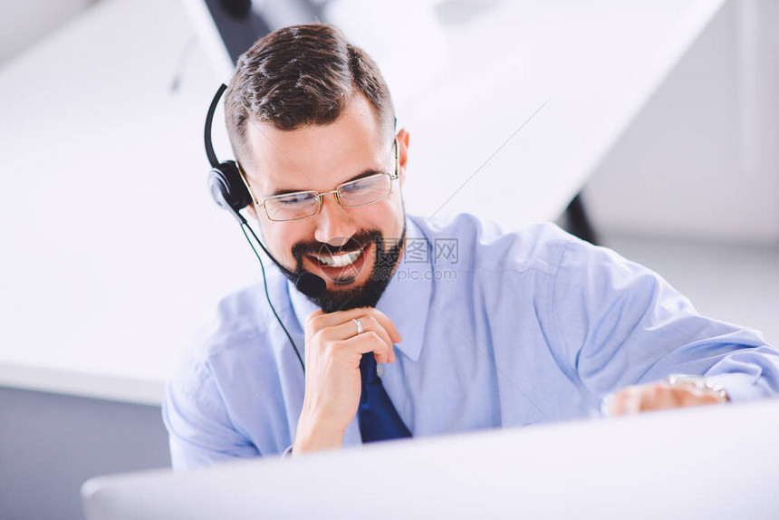 年轻微笑的客户支助操作员在办公室工作手图片