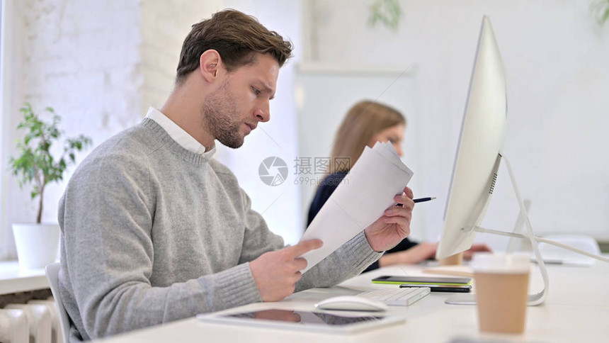 阅读文档和在桌面上工作的人图片