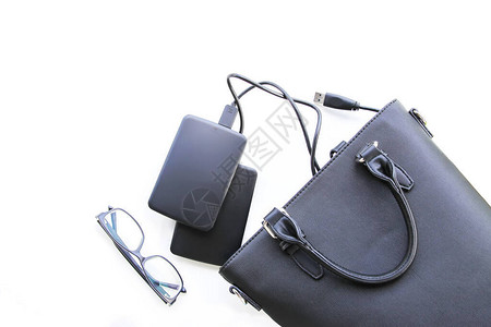 黑袋外部硬盘和白色背景上的眼镜的构成图片