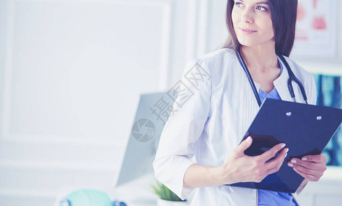 美丽的医生站在一个咨询室里她手里拿着一个文件夹图片