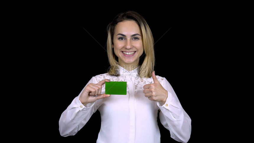 身着白衬衫的年轻女商人手里拿着一张银行卡图片