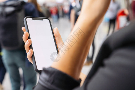 商业女商人手拿着带白色屏幕的黑手机背景图片