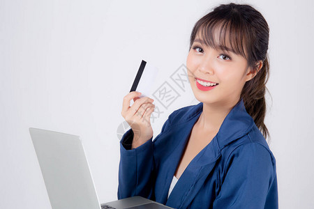美丽的年轻亚洲女商人高兴地拿着信用卡和笔记本电脑图片