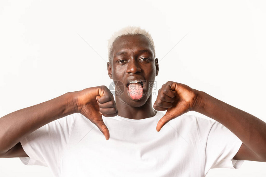 失望的非洲美国金发男子近距离露出拇指低头和舌头图片