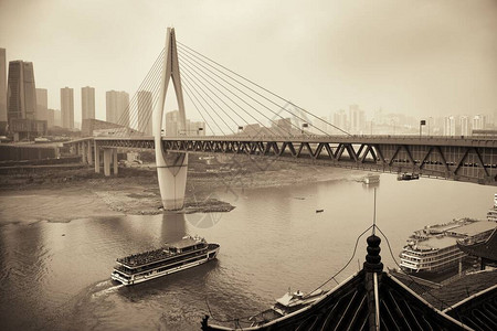 在重庆与城市建筑的桥下船经图片