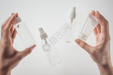 妇女用白底装满液体的瓶子图片