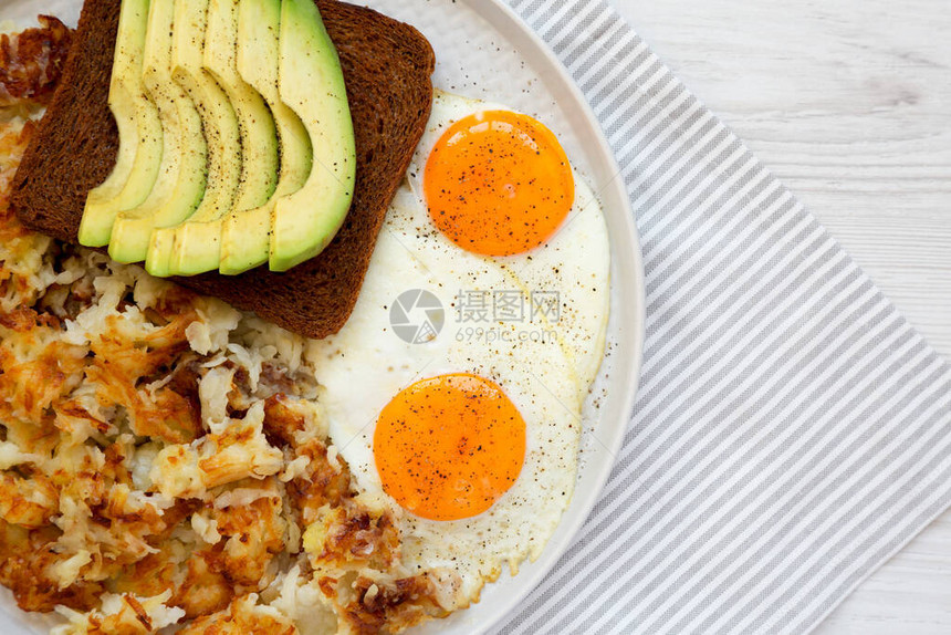 白色木质背景的盘子上的自制烤炸薯条和鸡蛋图片