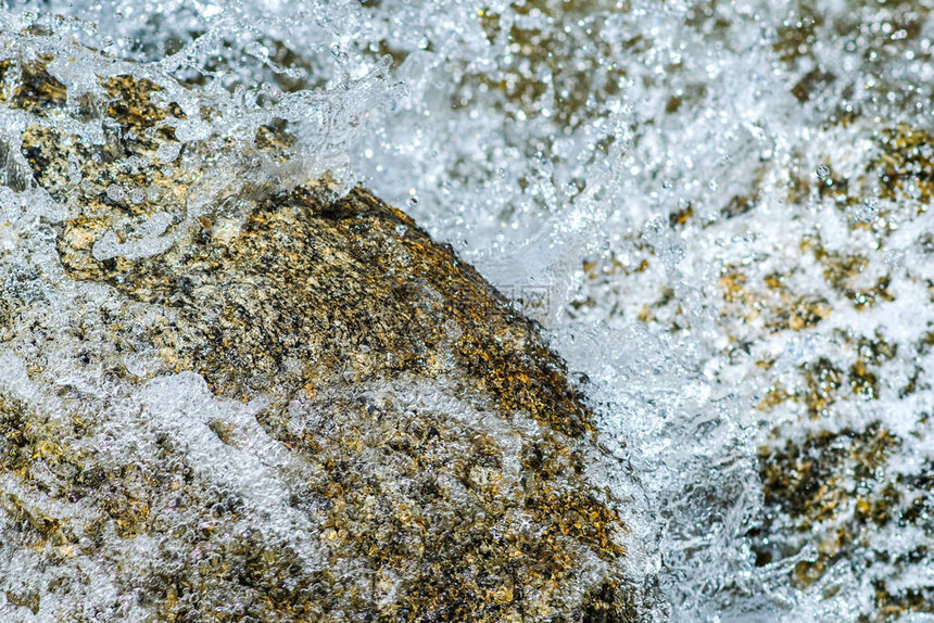 从岩石瀑布流出的新鲜清澈水滴紧图片