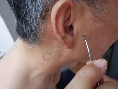 男人用清洁工具清洁他的内耳蜡图片