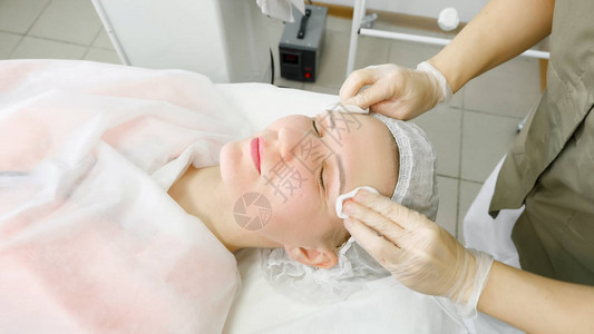 白消毒手套的美容沙龙理疗师在激光除毛近视后清图片