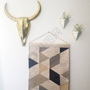 方形编织挂毯金属牛头和植物衣架装饰靠在白墙上编织壁挂具有几何图图片
