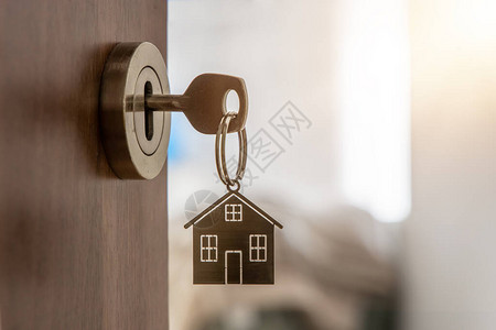 用钥匙和家形钥匙链打开通往新家的大门按揭投资不动产物图片