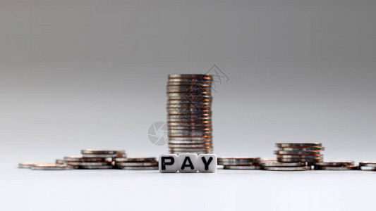 白方块装在PAY和一堆硬币的字眼里背景图片