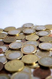 银和金欧元硬币散落在白色背景上大量的硬币象征着财富财富收入图片