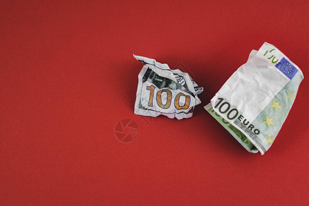 价值一百欧元和一美元的钞票躺在红图片