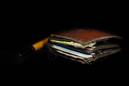 新真皮革钱包最亮的景象里面有钞票和信用卡黑底图片