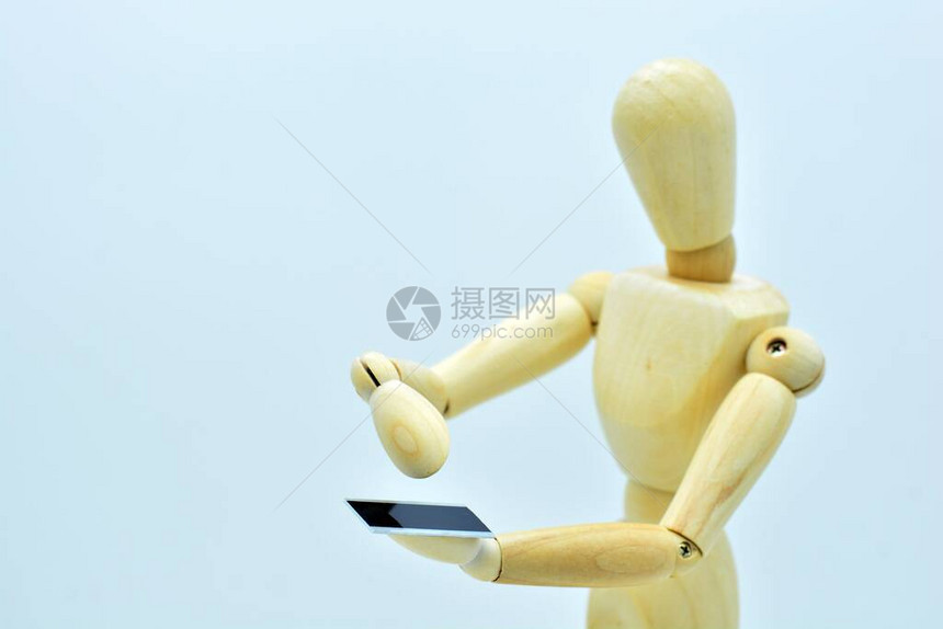 使用手机的木制人体模型图片