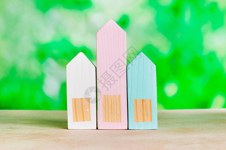 绿色背景模糊的木制玩具房屋文图片