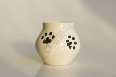 有猫腿的小白便壶猫爪的指纹陶瓷制品背景图片