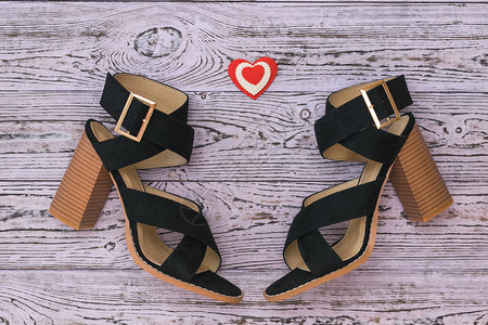 时髦的皮革女鞋和木制背景的心脏图片