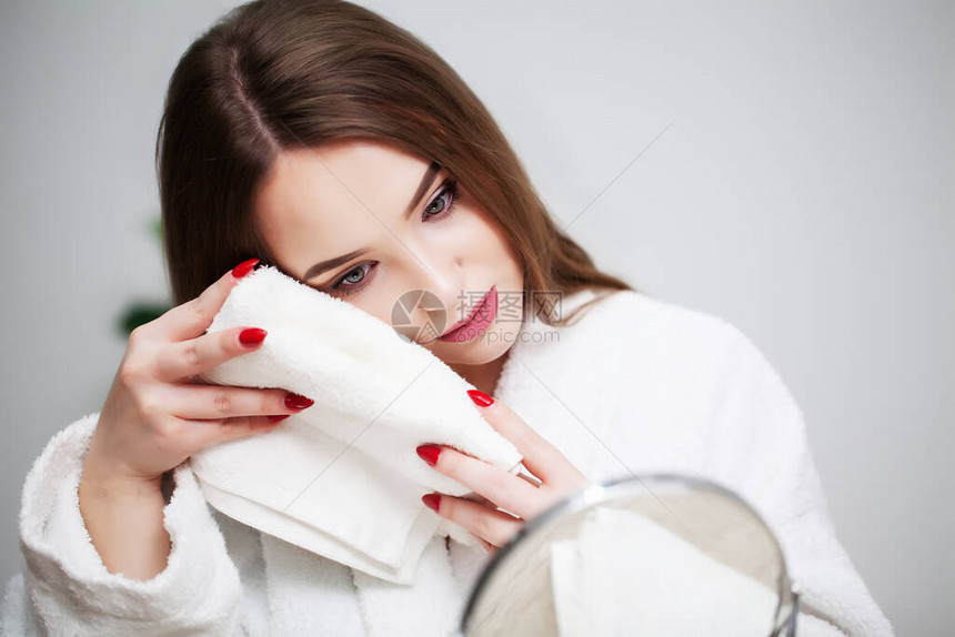 年轻女子在浴室用毛巾擦脸图片