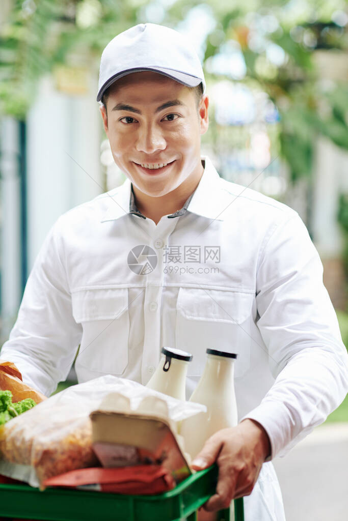 微笑越南信使运送牛奶鸡蛋和面包等新鲜产品的塑料图片