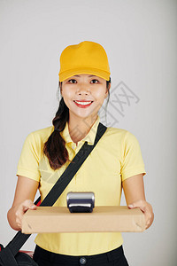 微笑着年轻漂亮的快递员送一盒披萨图片