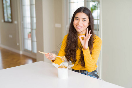 年轻女子在送货箱里吃面条用手指做好标记图片