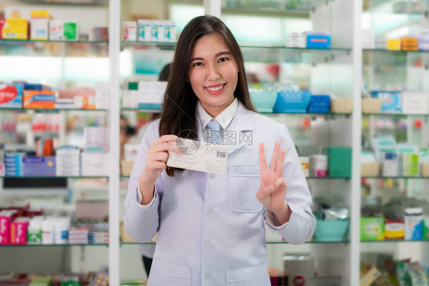 亚洲年轻女药剂师在药房店里用三根手指向她的顾客解释每天服用三粒药或三粒胶囊医学药剂学医疗保图片