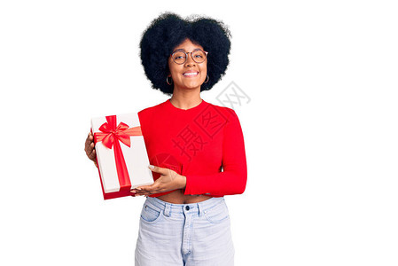 年轻的美国女孩拿着礼物面带快乐和凉爽的笑图片