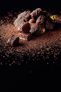 各种巧克力糖果和巧克力薯片在黑色反射背景上复制空图片