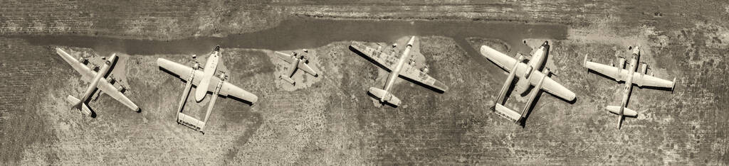 在一个小型农村机场对称停靠的轻型老式飞机从空中上向下俯瞰图片