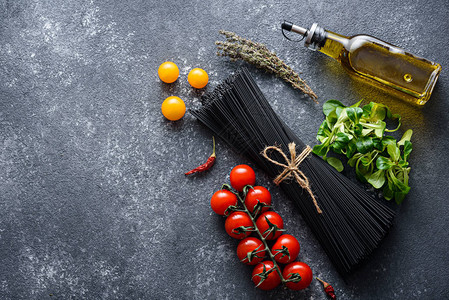 黑色面食番茄橄榄油生菜灰底辣椒和复印空间图片
