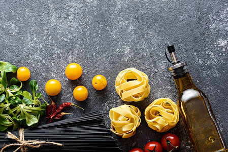 黑色木板上的意大利面和黄色小番茄图片